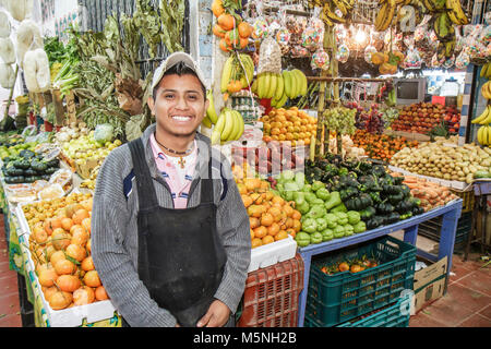 Cancun Messico, Messico Mercado ispanico uomo maschio indossando grembiule locale, produrre venditore bancarella mercato vendere verdure frutta zucca patate cassette Foto Stock