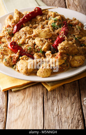 Il cibo indiano: Chettinad pollo al curry con peperoncino closeup sul piano verticale. Foto Stock