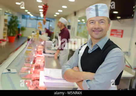 Ritratto di felice macelleria maschio nella sezione kosher al supermercato Foto Stock
