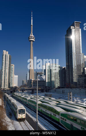 Andare i treni nel centro cittadino di Toronto e in attesa di ora di punta con la CN Tower, il Rogers Centre Stadium e highrise condominiums Foto Stock