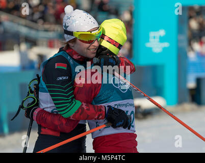 Pyeongchang, Corea del Sud. Il 25 febbraio, 2018. PyeongChang, Corea del Sud - CHI CHUNXUE, a destra della Cina abbracci VALIANTSINA KAMINSKAYA della Bielorussia, l'ultima unità di finitura in sci di fondo: Ladies' 30km mass start Classic presso Alpensia Sci di fondo Centro. Kaminskaya era l'ultimo atleta di terminare un evento durante il 2018 Pyeongchang Giochi Olimpici invernali il 25 febbraio 2018. Credito: Paolo Kitagaki Jr./ZUMA filo/Alamy Live News Foto Stock