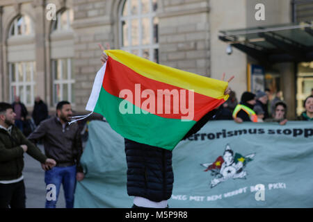 Mannheim, Germania. Il 25 febbraio 2018. Un manifestante curdo può contenere fino a bandiera di Rojava. Turchi e curdi manifestanti di fronte gli uni degli altri in occasione delle proteste nel centro della città di Mannheim. Il bagno turco manifestanti hanno sostenuto l'attacco da parte dell'esercito turco sulla città siriana di Afrin, il quale è controllato dal popolare curda Unità di Protezione (YPG). Il contatore curda manifestanti hanno chiesto lo stato turco i terroristi per l'attacco. Foto Stock