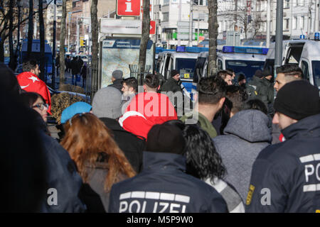 Mannheim, Germania. Il 25 febbraio 2018. Un manifestante indossando una bandiera turca oltre alle sue spalle è raffigurato, lasciando la protesta. Turchi e curdi manifestanti di fronte gli uni degli altri in occasione delle proteste nel centro della città di Mannheim. Il bagno turco manifestanti hanno sostenuto l'attacco da parte dell'esercito turco sulla città siriana di Afrin, il quale è controllato dal popolare curda Unità di Protezione (YPG). Il contatore curda manifestanti hanno chiesto lo stato turco i terroristi per l'attacco. Foto Stock