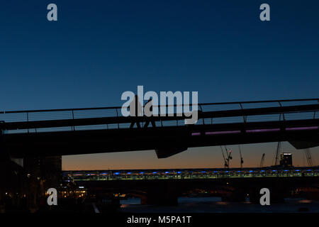 Londra, Regno Unito. Il 25 febbraio 2018. Regno Unito meteo. Un bel tramonto lungo il fiume Tamigi. Sagome di persone sul Millennium bridge con Blackfriars Rail Bridge dietro. Credito: Carol moiré/Alamy Live News. Foto Stock