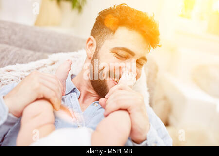Padre mantiene i piedi del suo piccolo bambino Foto Stock