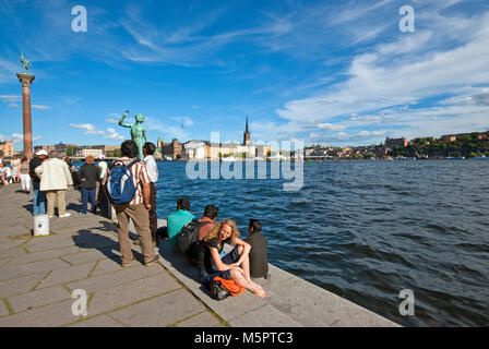 Persone relax al City Hall Park vicino alla statua di Carl Eldh (canzone) e la colonna con la statua di Engelbrekt Engelbrektsson, Stoccolma, Svezia Foto Stock