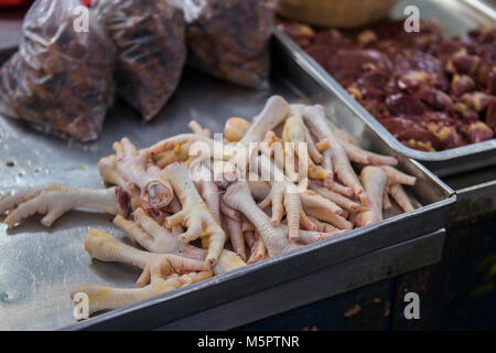 Pila di pollo crudo i piedi sono in vendita su un mercato in Borneo Foto Stock