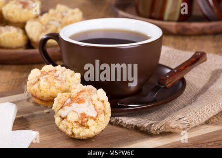 Primo piano della cannella crema di formaggio cakeand caffè tazza di caffè su un vassoio in legno Foto Stock