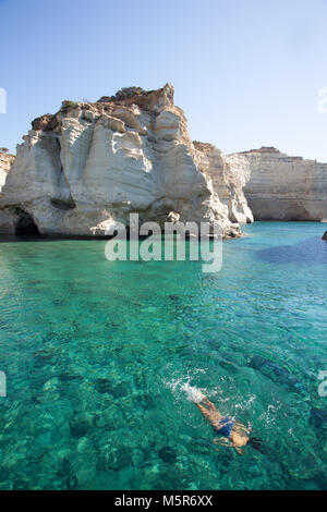 Un ragazzo di immersioni in acque cristalline di isola di Milos, durante il Daily tour in barca, Milos,Grecia Foto Stock