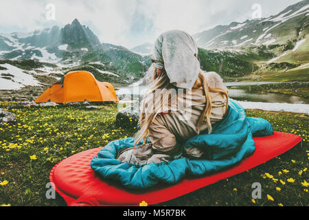 Donna relax nel sacco a pelo sul tappeto rosso Campeggio Vacanze viaggi in montagna il concetto di stile di vita di avventura all'aperto il weekend di natura selvaggia Foto Stock