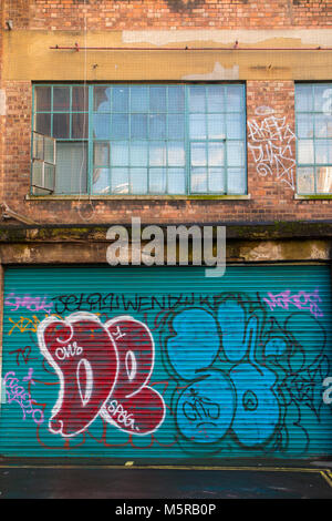 Un vecchio edificio adibito a magazzino di Soho, decorato con graffiti e atti di vandalismo Foto Stock