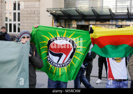 Mannheim, Germania. Il 25 febbraio, 2018. Manifestanti curdi può contenere fino a bandiera di Antifa Enternasyonal e una bandiera di Rojava. Turchi e curdi manifestanti di fronte gli uni degli altri in occasione delle proteste nel centro della città di Mannheim. Il bagno turco manifestanti hanno sostenuto l'attacco da parte dell'esercito turco sulla città siriana di Afrin, il quale è controllato dal popolare curda Unità di Protezione (YPG). Il contatore curda manifestanti hanno chiesto lo stato turco i terroristi per l'attacco. Credito: Michael Debets/Pacific Press/Alamy Live News Foto Stock