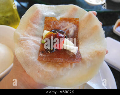 Anatra alla Pechinese piatto, compresa l'Anatra di pechino è croccante pelle arrosto, molla cipolla, peperoncino dolce e salsa di soia, che quindi laminato in cinese pancake wrap Foto Stock