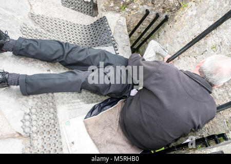 Un visitatore stabilisce torna a baciare la Blarney Stone con l aiuto di un membro del personale nella parte superiore di Blarney Castle a Blarney Castle in Irlanda meridionale Foto Stock