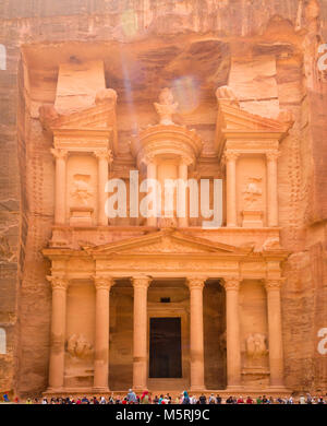 PETRA, Giordania, 25 Aprile 2016: i visitatori a sedersi su una mensola della sorprendente tesoro, scolpito in pietra nel rose red città di Petra, un patrimonio mondiale Herita Foto Stock