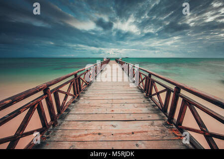 Basso angolo vista del molo di legno raggiungendo il turchese del mare dei Caraibi Foto Stock