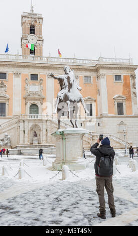 Roma, Italia. Il 26 febbraio, 2018. Un uomo le fotografie la coperta di neve la statua dell'Imperatore Marco Aurelio sul Capital Hill in snow colpire Roma Credit: stephen Bisgrove/Alamy Live News Foto Stock