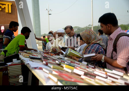 Dacca, Feb. 26. Il 1° febbraio 2018. I visitatori di leggere su libri in una fase di stallo nel Amar Ekushey Boi Mela, che letteralmente significa "immortale venti prima fiera del libro,' di Dacca, capitale del Bangladesh, nel febbraio 26, 2018. Il Bangladesh più grande del mese-lungo annuale Fiera del libro sono iniziate il 1 febbraio 2018. Credito: Salim reza/Xinhua/Alamy Live News Foto Stock