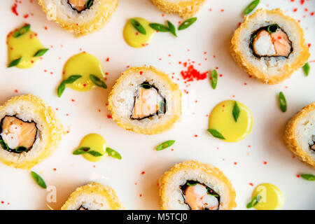 Rotoli di sushi sparsi su sfondo bianco Foto Stock