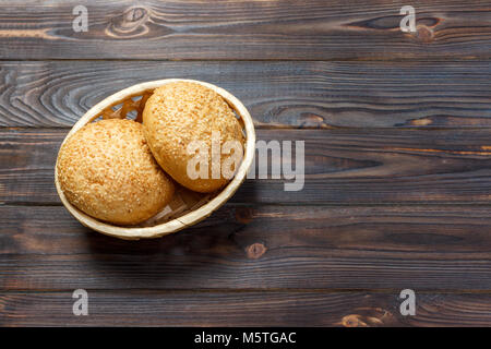 Round panini con semi. Il pane nel cestello. Pane appena sfornato rotoli con seme. Foto Stock