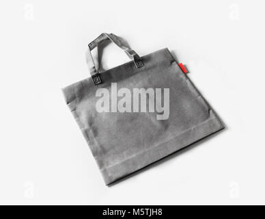 Grigio bianco shopping borsa di tela sul libro bianco sullo sfondo. Foto Stock