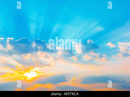 Sunrise drammatico blu cielo con orange raggi solari rottura attraverso le nuvole. La natura dello sfondo. Il concetto di speranza. Foto Stock