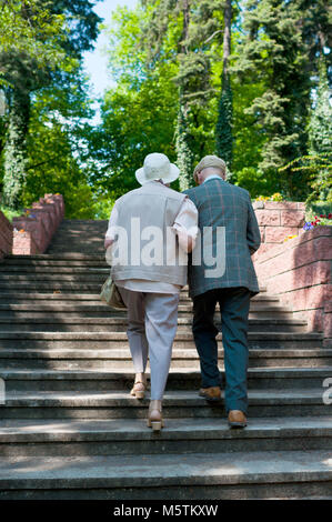 Gli anziani sulla pensione di anzianità sono andando lungo le scale attraverso il parco Foto Stock