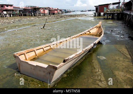 Nave allagata nel fango al villaggio su pilastri. Barca abbandonata al clan sporti di George Town, Penang, Malaysia. Foto Stock