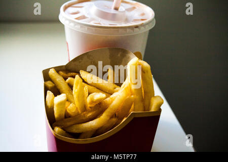 Bere e patatine fritte su sfondo bianco Foto Stock