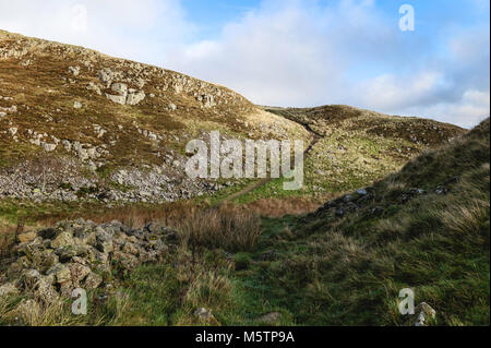 Passeggiate attraverso i peel falesie lungo il vallo di Adriano sentiero su un autunno mattina vicino a Hexham, Northumberland, Regno Unito. Foto Stock