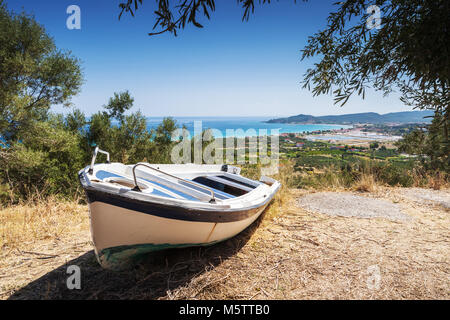 Il vecchio pesca bianca riga barca sulla costa. Paesaggio estivo dell'isola di Zante, Grecia Foto Stock