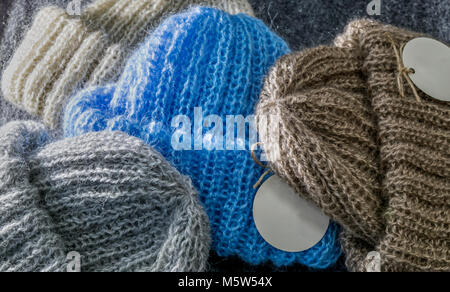 Pila di quattro fatti a mano calda inverno cappelli per donne blu, marrone, beige e grigio Foto Stock