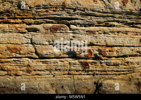 Pietra naturale dello sfondo. Close-up di una parete di rufous stratificata di ardesia di montagna. Foto Stock