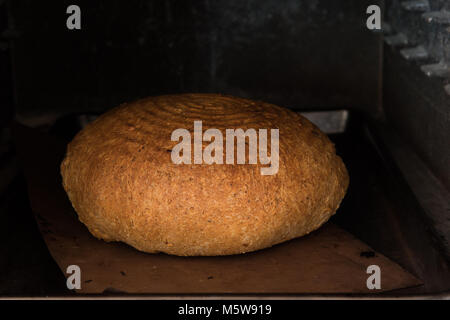 In casa il pane fatto a mano la cottura in forno Foto Stock