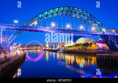 Newcastle Tyne Bridge, vista notturna dell'iconico Tyne Bridge con l'edificio Glasshouse e il Millennium Bridge in lontananza, Inghilterra, Regno Unito Foto Stock