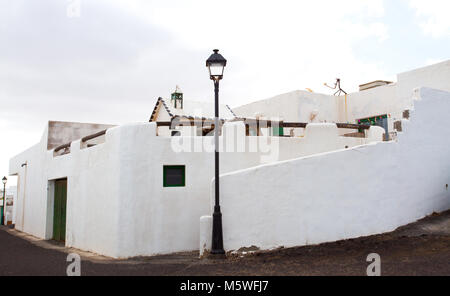 Angolo di strada con una tipica singola piani casa bianca nel villaggio costiero di Los Cocoteros, Lanzarote, Spagna Foto Stock