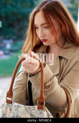 Donna che guarda nella sua borsa per oggetti rubati Foto Stock