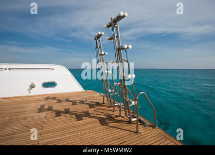 Metallo Acciaio scale sul retro pontatura in teak di un lussuoso yacht a motore vela su un oceano tropicale Foto Stock