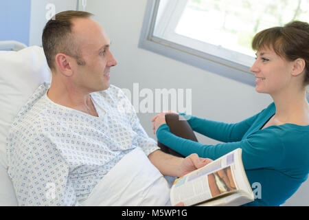 Senior donna visitando il marito in ospedale Foto Stock