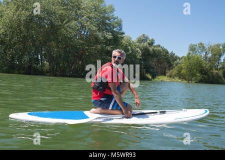 Coppia attraente rider contemplando la natura seduta sulla scheda pala Foto Stock