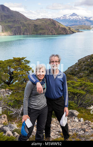 Coppia sposata si pongono per la fotografia; Lago Nordenskjold al di là; Parco Nazionale Torres del Paine; Cile Foto Stock