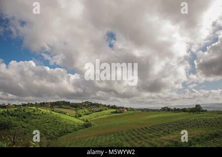 Panoramica del campo, foreste e colline con villa al top nella campagna Toscana, una regione tradizionale nel centro della penisola italiana. Foto Stock