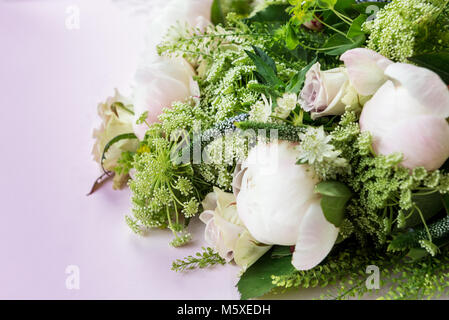 Bouquet di fiori da grandi peonie, pastello rose, pesche profumate di scorte e selvaggio, meadowy fronde su sfondo chiaro Foto Stock