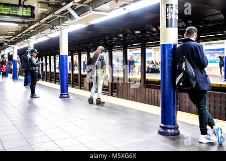 La città di New York, Stati Uniti d'America - 28 Ottobre 2017: Attesa di persone in transito sotterraneo vuoto grande piattaforma in NYC Stazione della metropolitana nel centro cittadino, Fulton Street Foto Stock