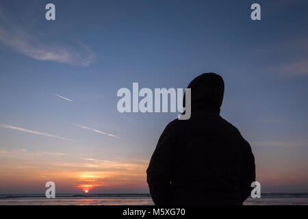 Freddo,l'inverno,gli inverni,giorno,vestito,a,warm,abbigliamento,guardare,guardare,sun,Tramonto,Ynyslas,Beach,Ceredigion,Galles,UK,U.K., Foto Stock