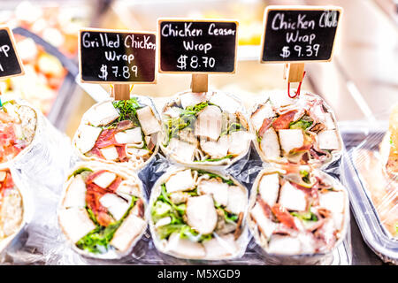Segni, prezzi sul display club di pollo, grigliate e ceasar panini con tortilla avvolgere, pomodori, carne in negozio, negozio, fast food confezionato in plastica Foto Stock