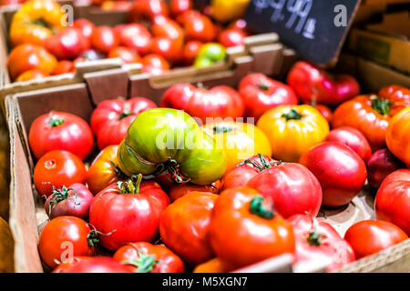 Primo piano di molti succoso e vibrante, mature grande rosso, giallo, verde cimelio di pomodori sul display farmers market shop negozio alimentari in scatole con Foto Stock