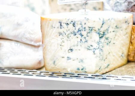 Macro closeup di formaggio blu chunk hunk grande pezzo avvolto in involucro di plastica sul display in vendita in negozio alimentari gourmet shop che mostra lo stampo Foto Stock