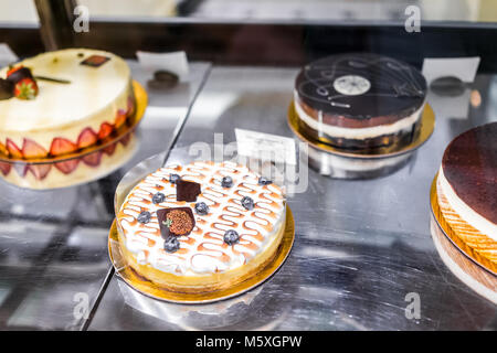 Molti dolci sul display in un panificio negozio con il Tiramisù, crema meringa, mirtillo decorazioni di zucca holiday caduta stagione autunnale, panna montata Foto Stock