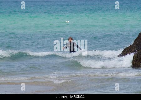 Attraente British Surfer, Bodysurfing in estate turchese del mare di Holywell Bay, North Cornwall, Regno Unito. Foto Stock